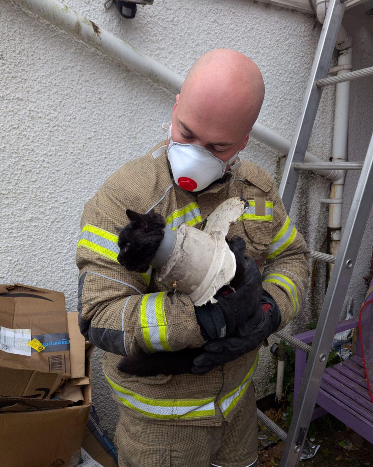 rescuer holding cat with drainpipe plastic