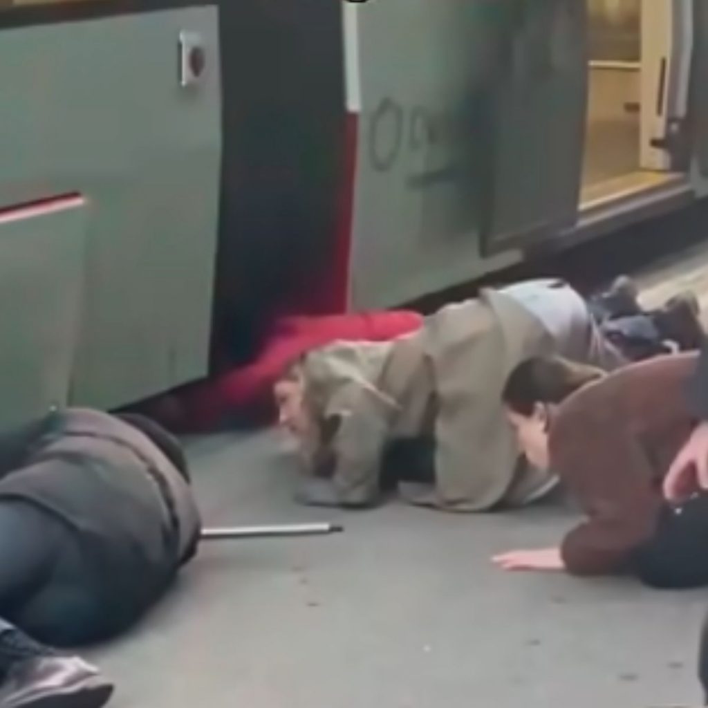 a group of people huddled under the tram