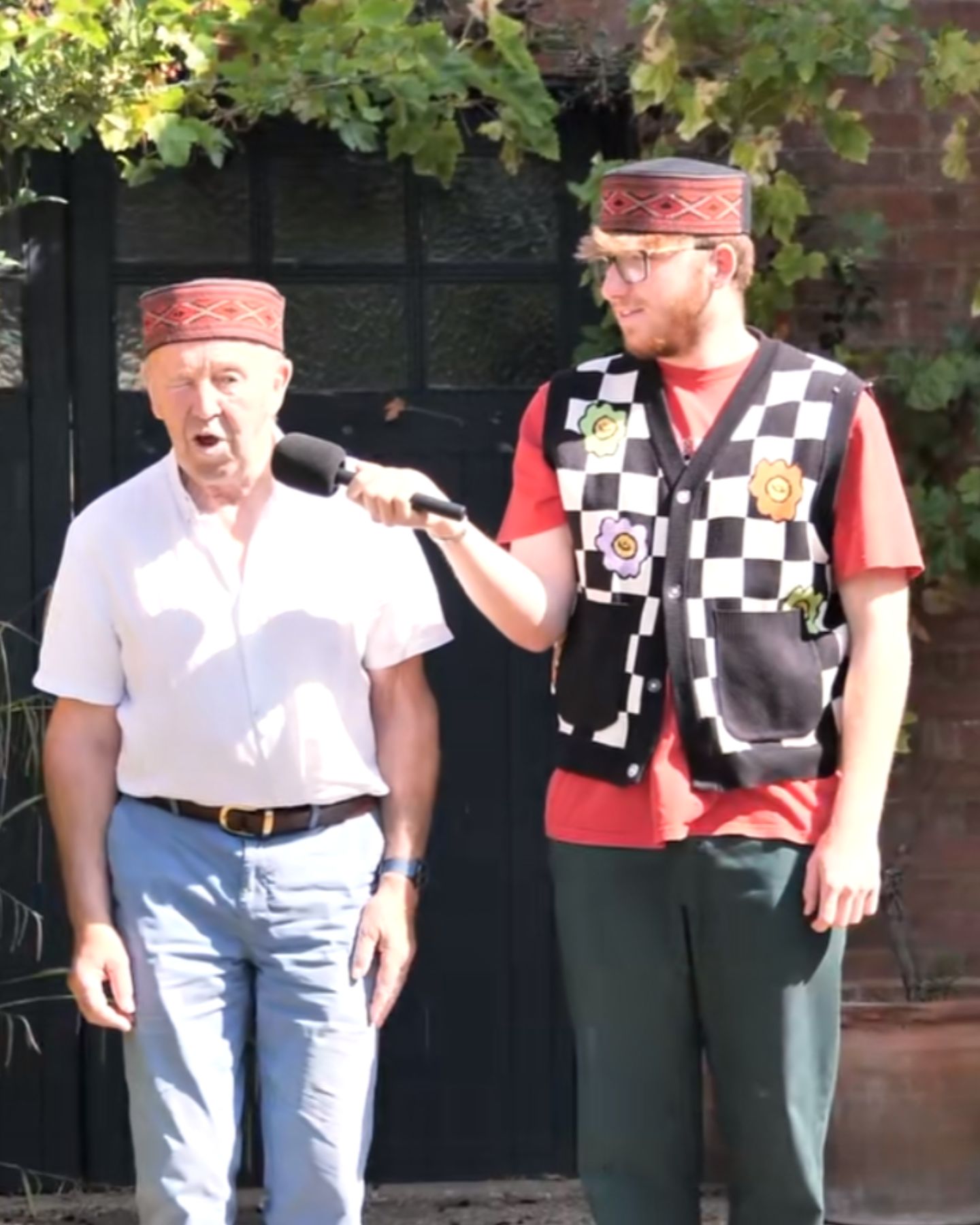 an old man sing on microphone held by young man