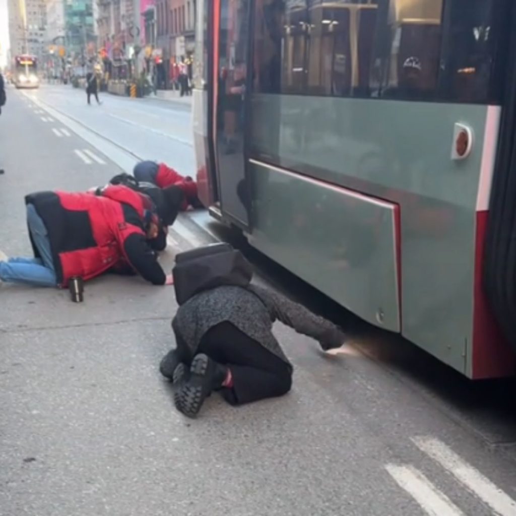 people huddle under the tram and flash their cell phones