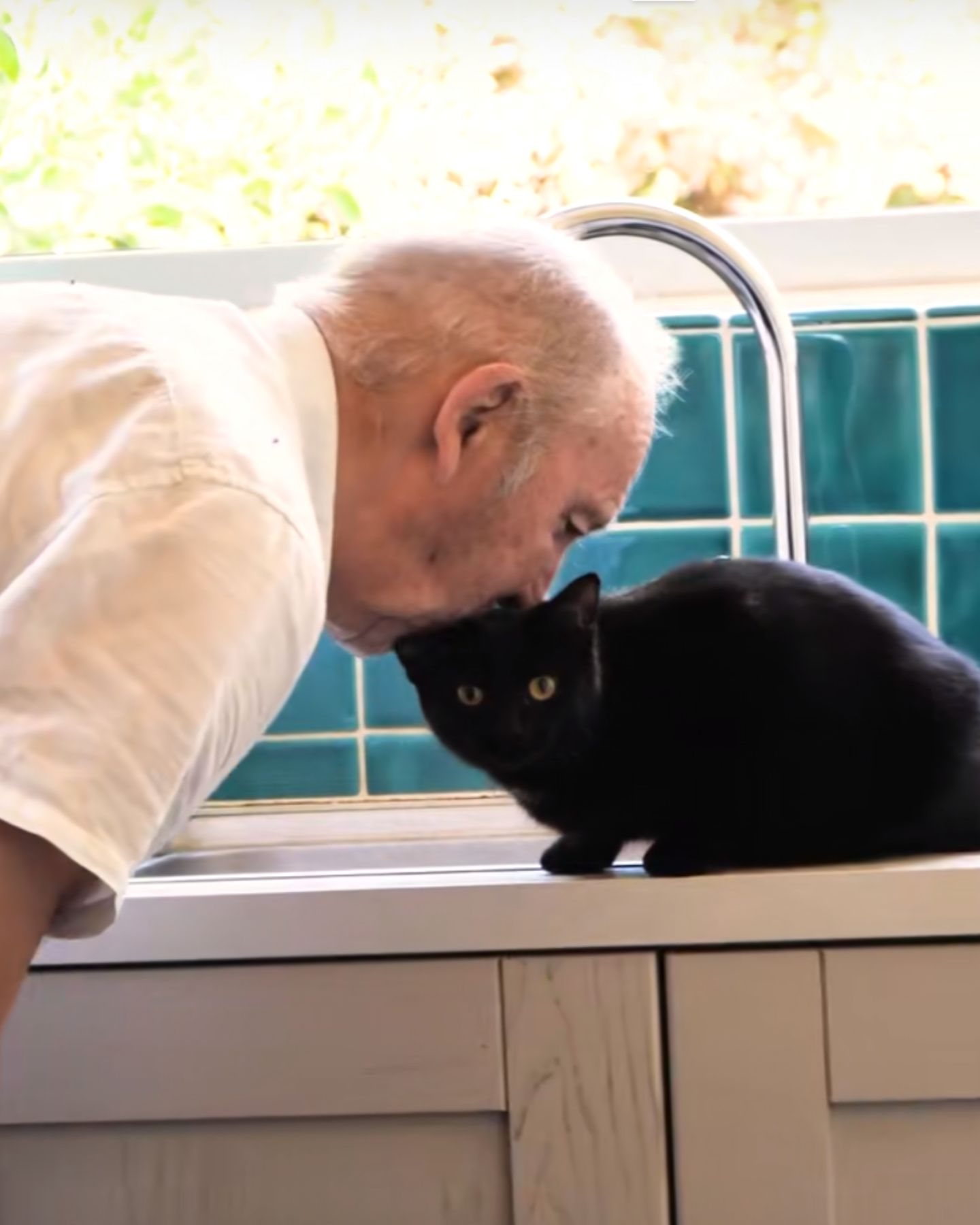 senior man kissing cat