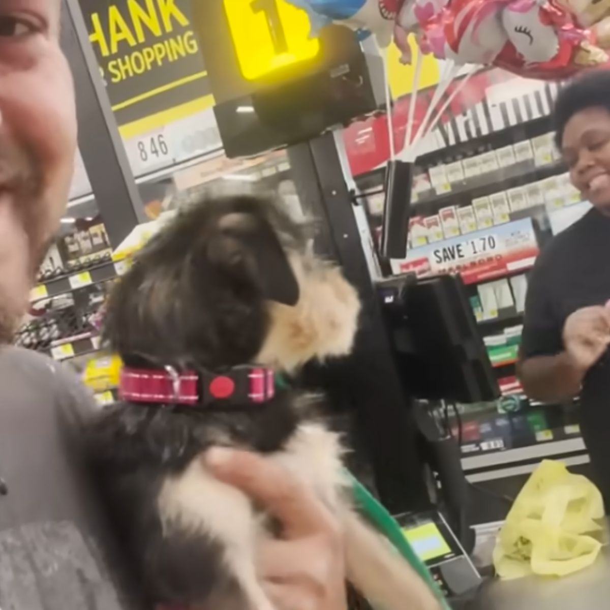 man in store holding a dog