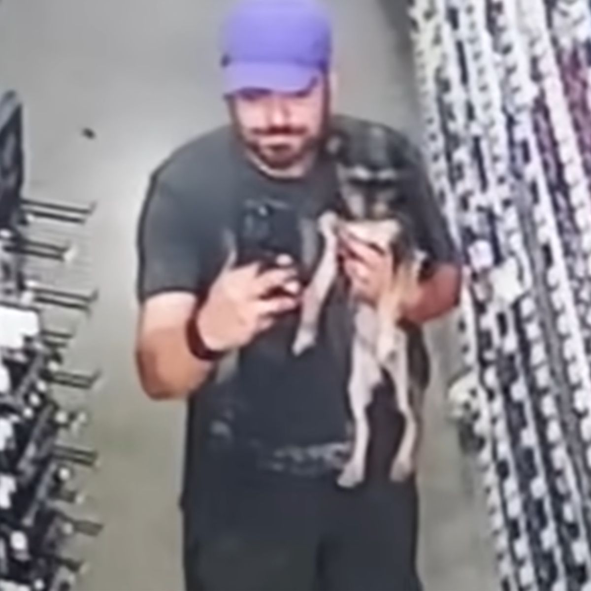 man with cap holding a dog