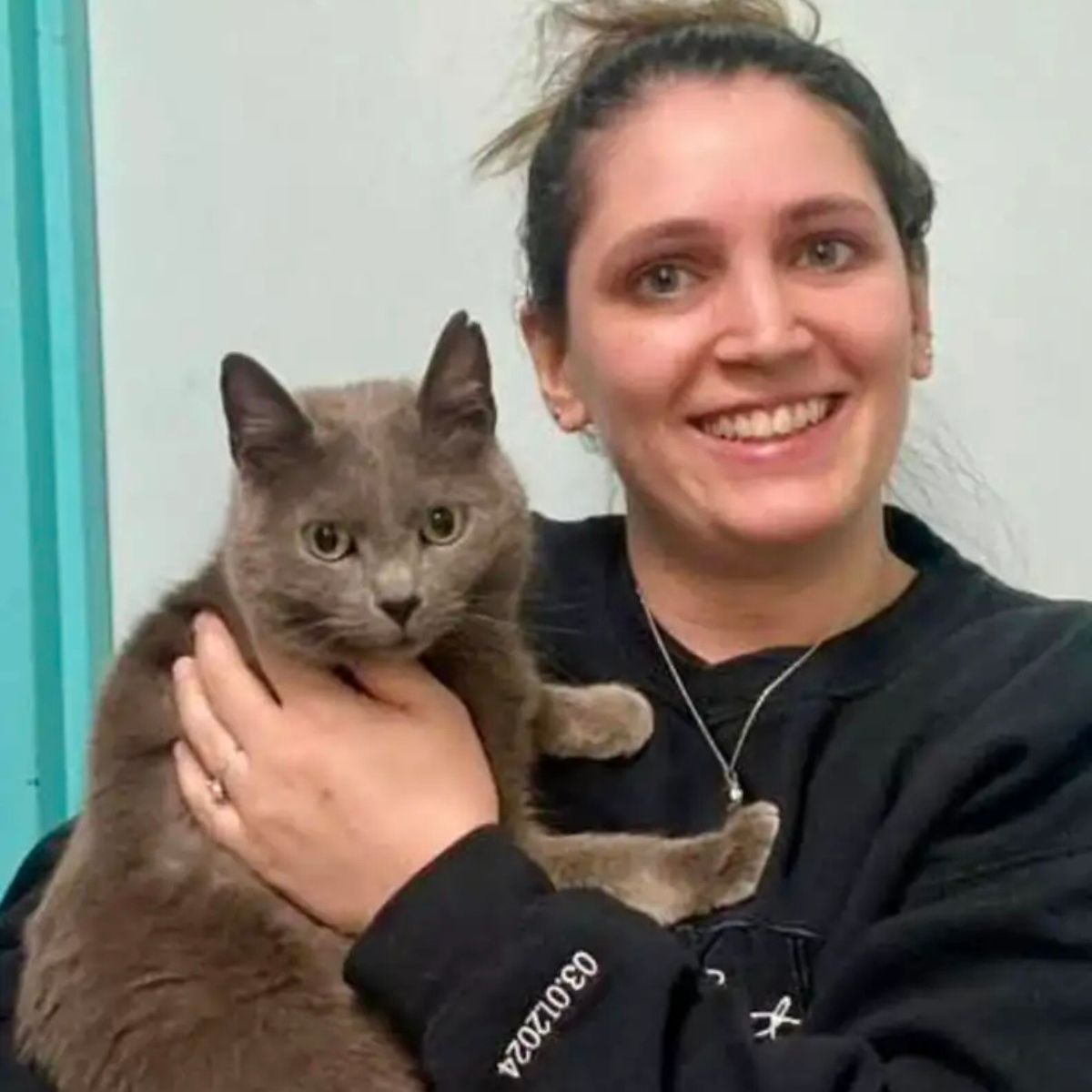 woman holding a gray cat