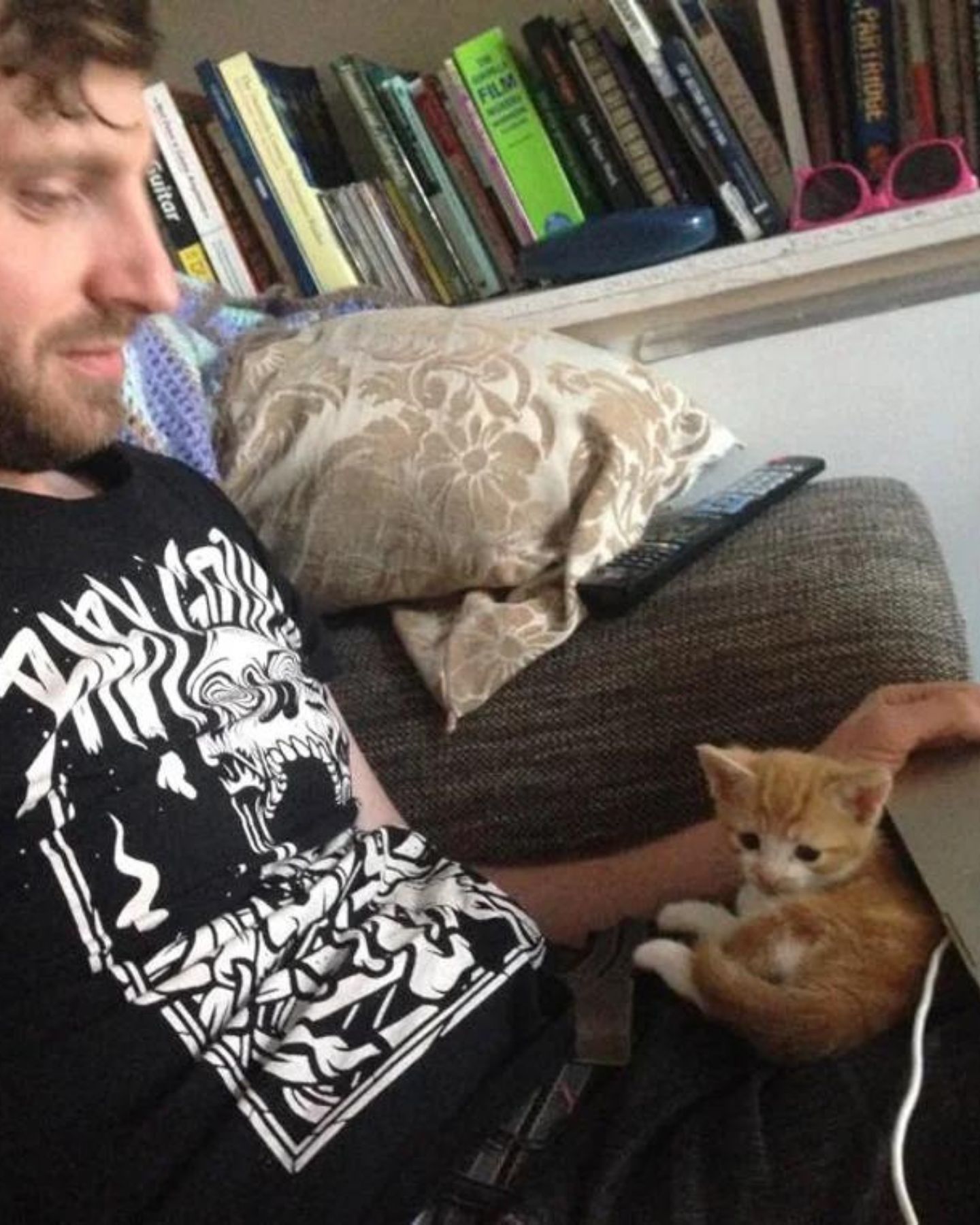 man holds kitten in lap