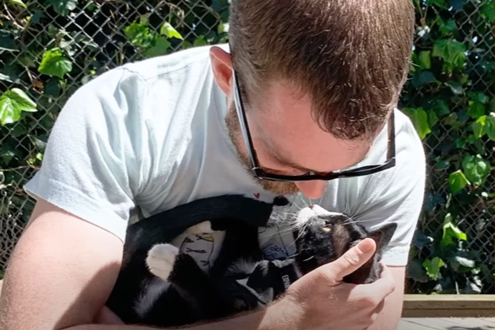 man hugs rescued cat