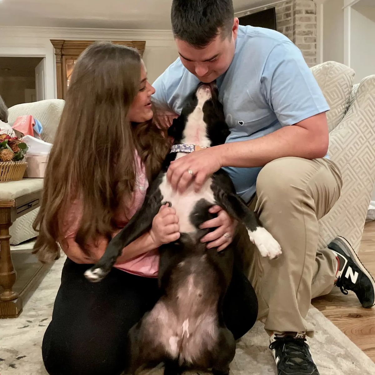 man and woman petting the dog