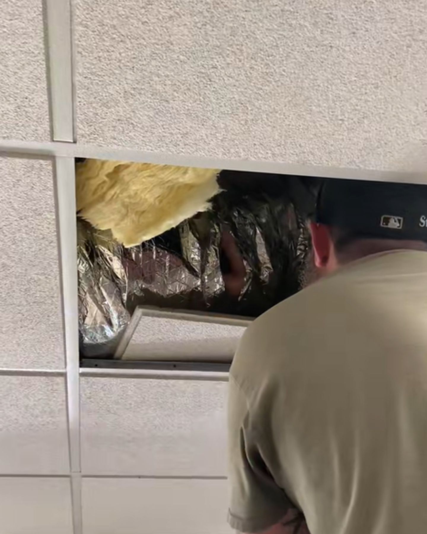 man checking the ceiling vent