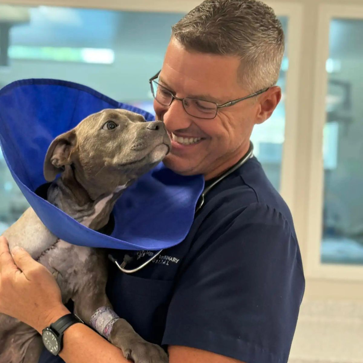 man holding the pup with a blue cone