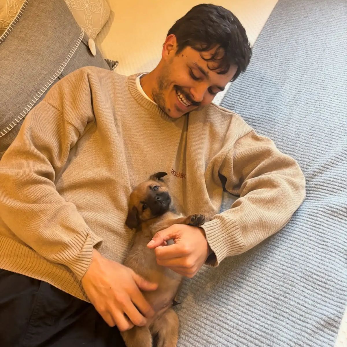 man lying with a puppy