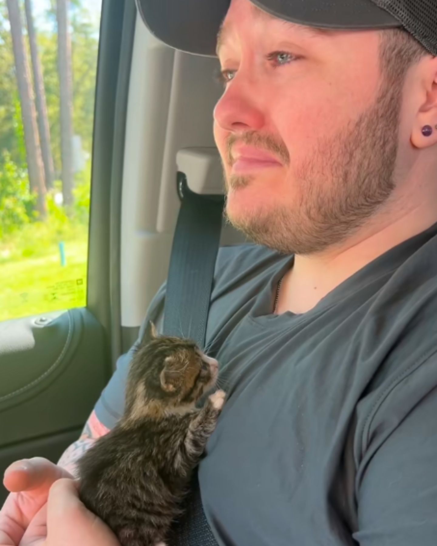 man with kitten in car