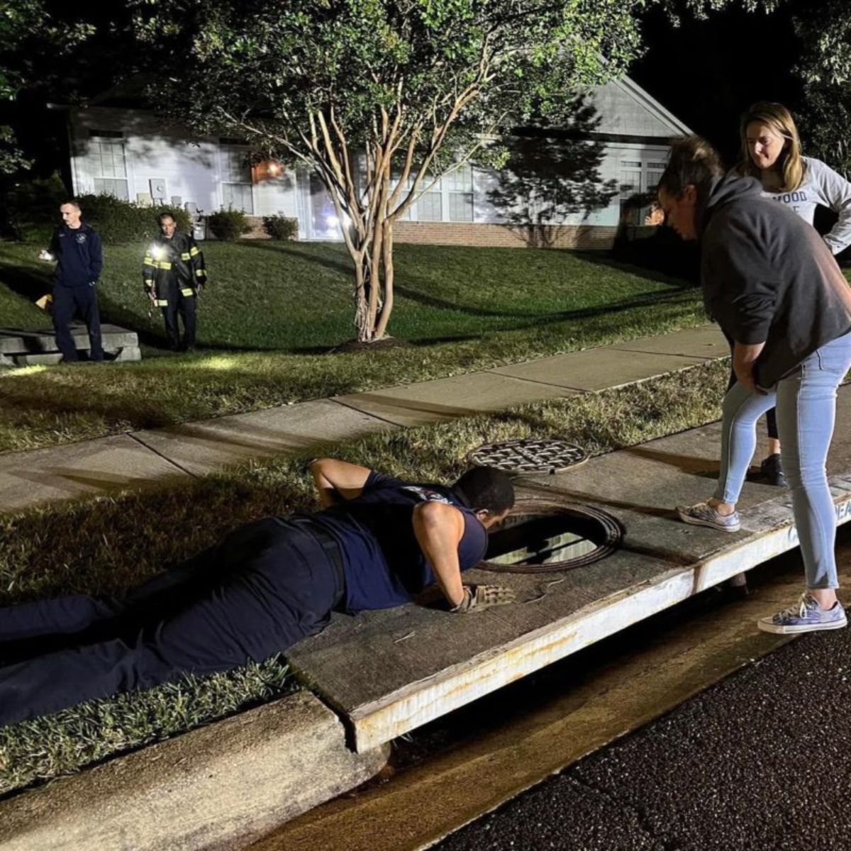 people looking in the storm drain