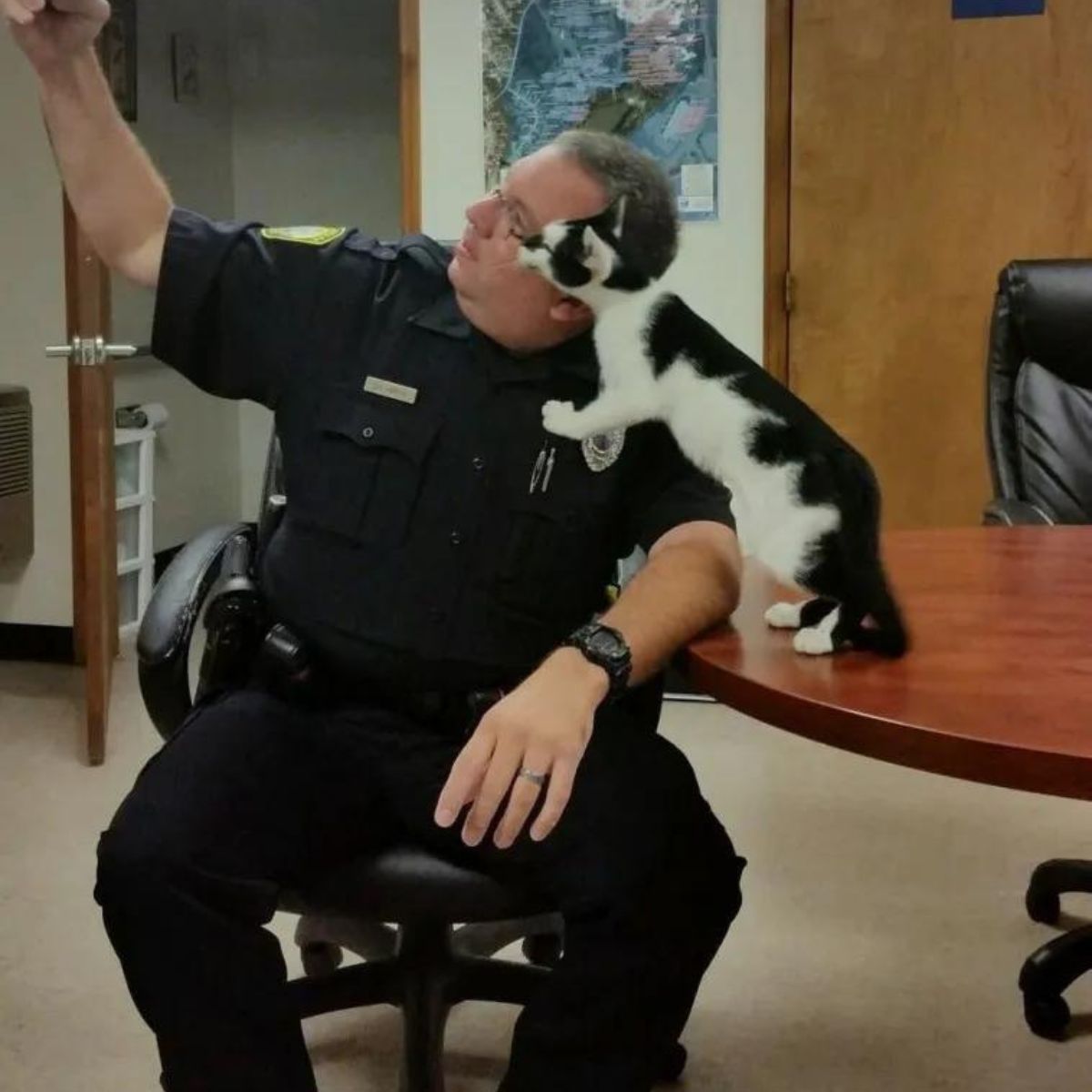 policeman takes a picture with a cat