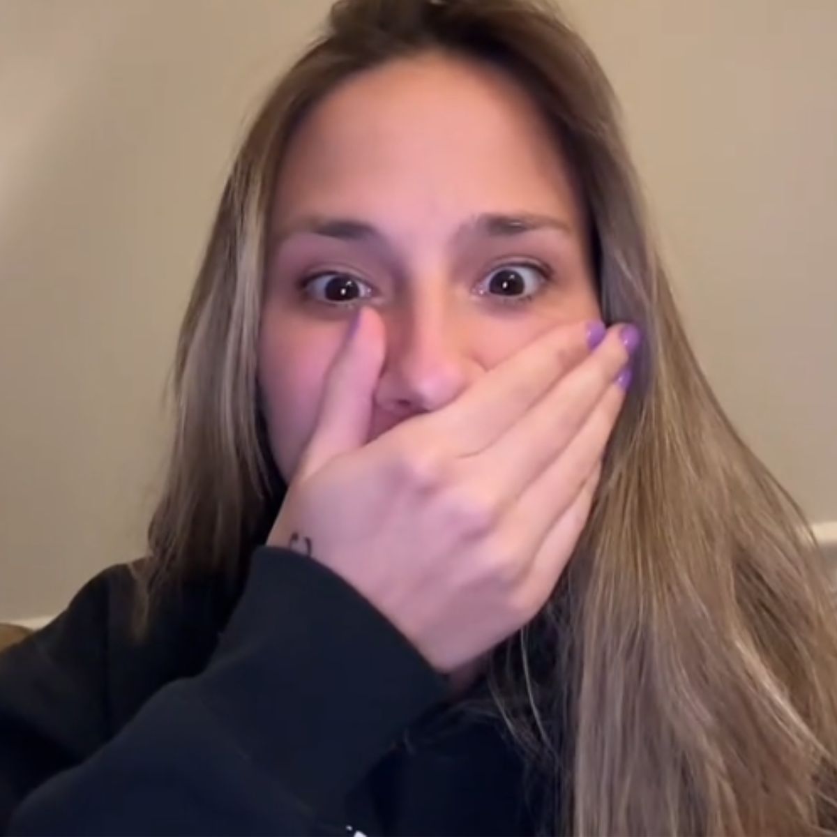 surprised woman with her hand over her mouth