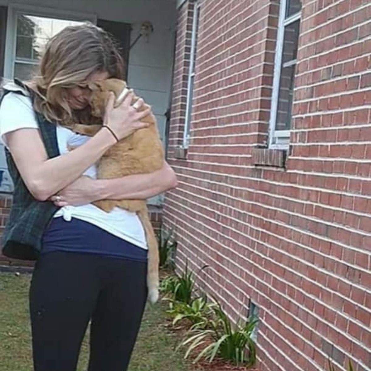 woman and a cat are cuddling outside