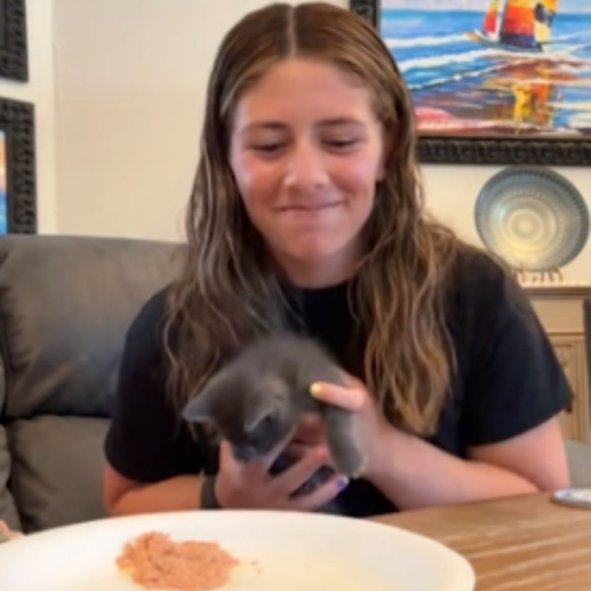woman holding a gray kitten