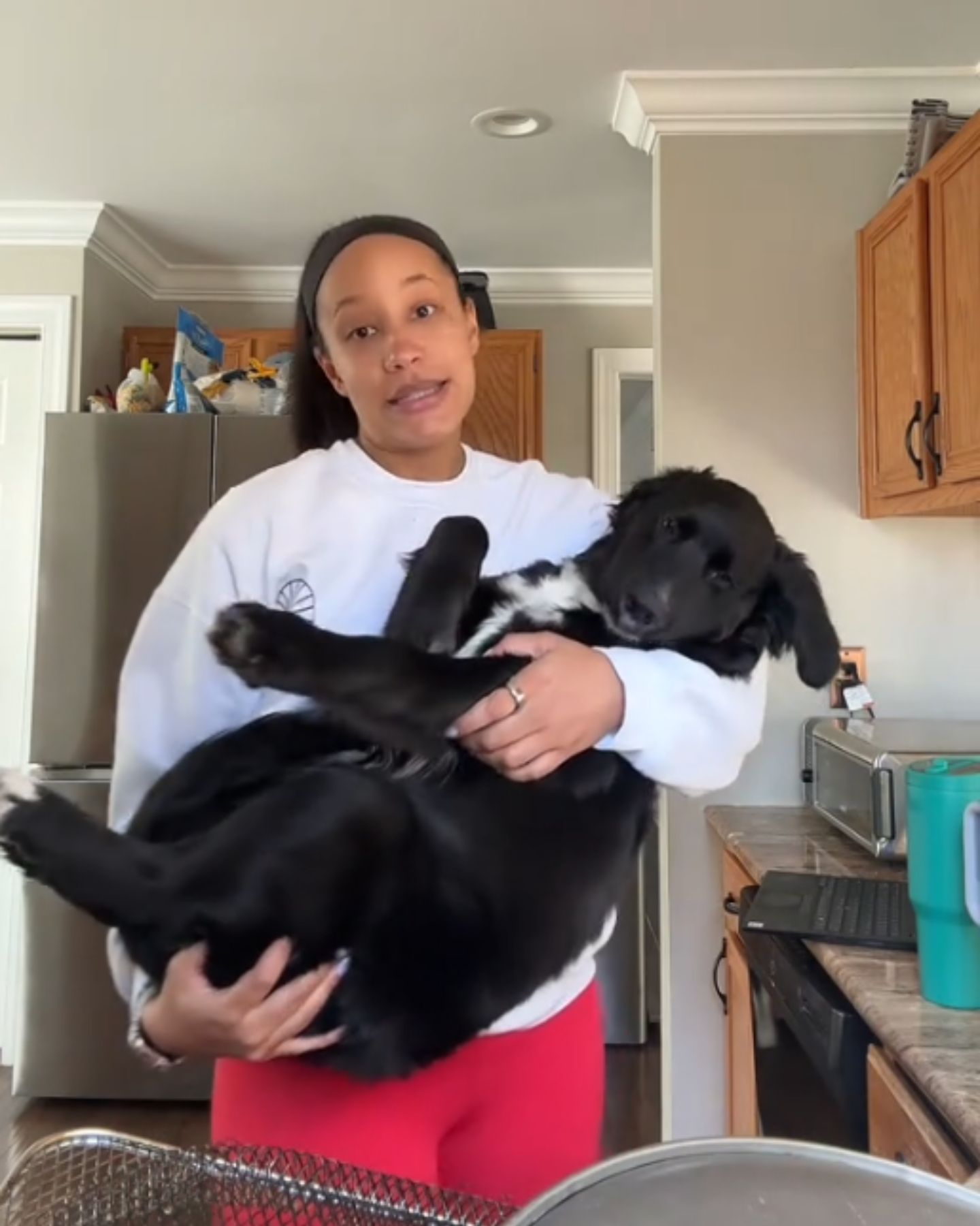 woman holding the black dog