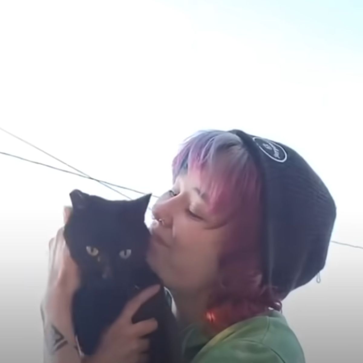 woman kissing black cat