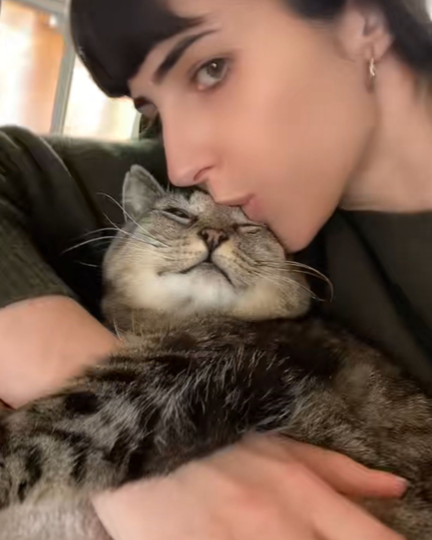 woman kissing cat