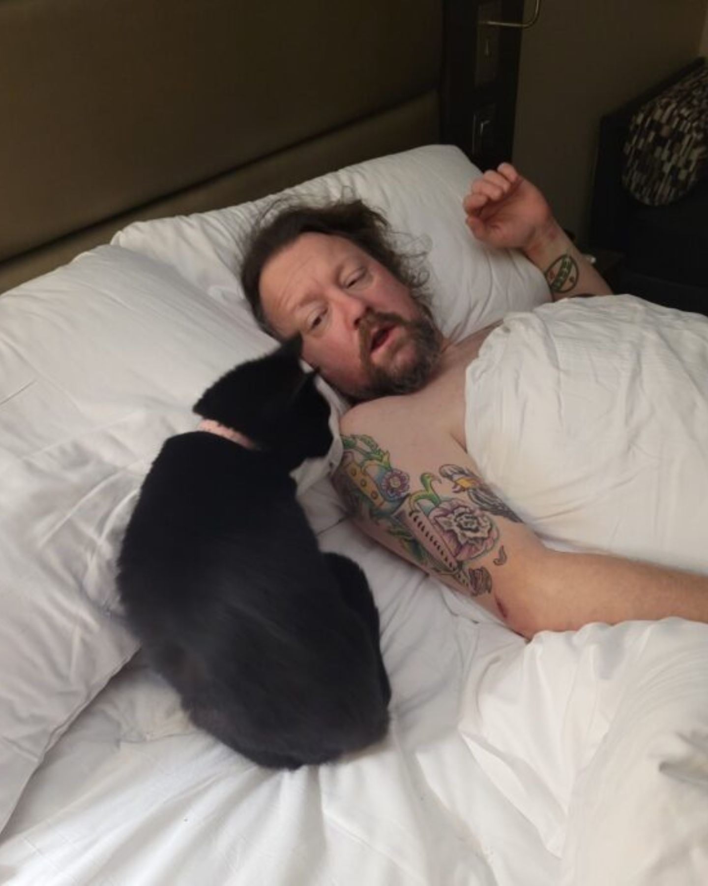 cat lying next to a man
