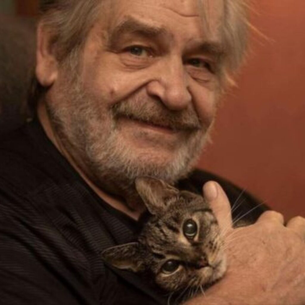 older man holding a cat