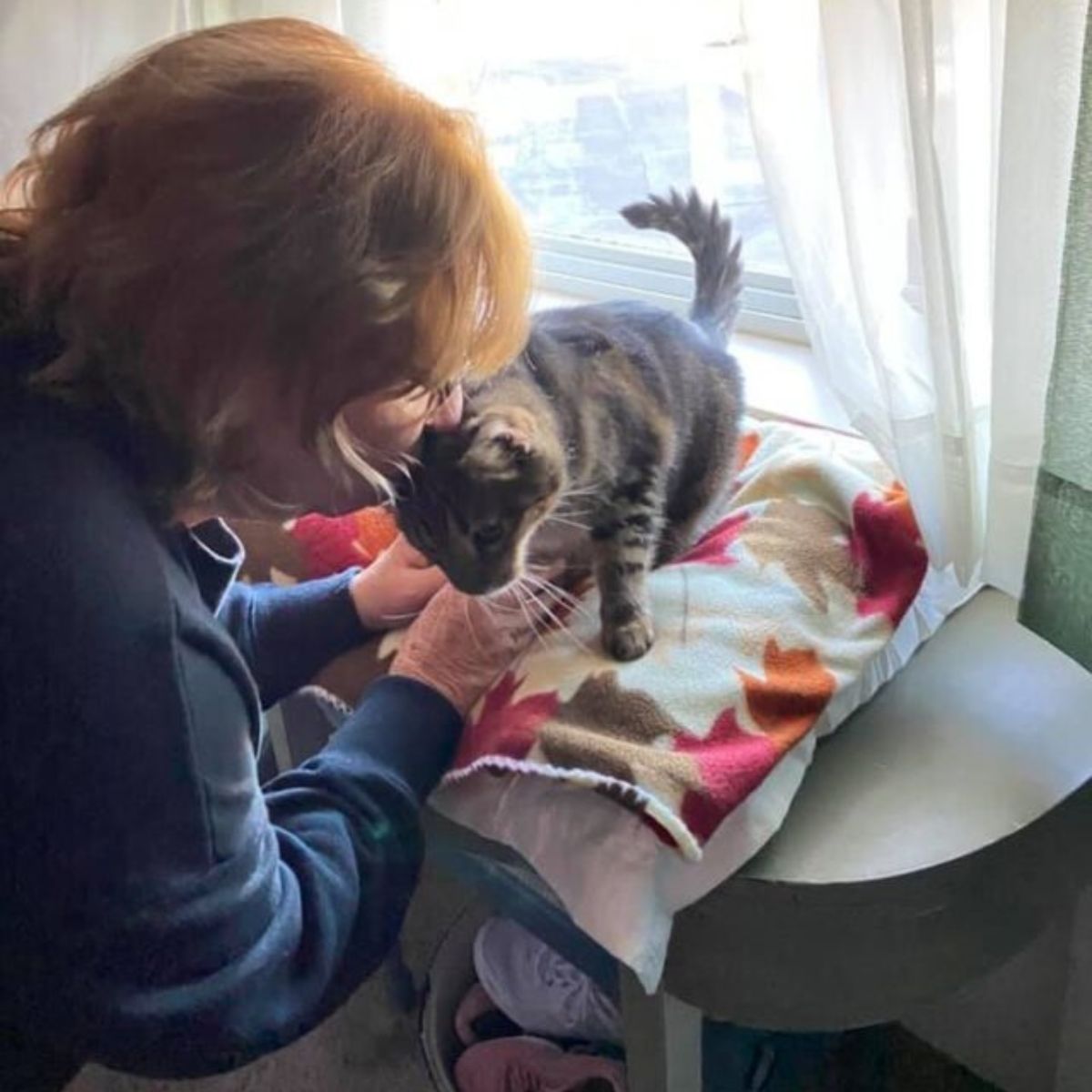 older woman kissing her cat