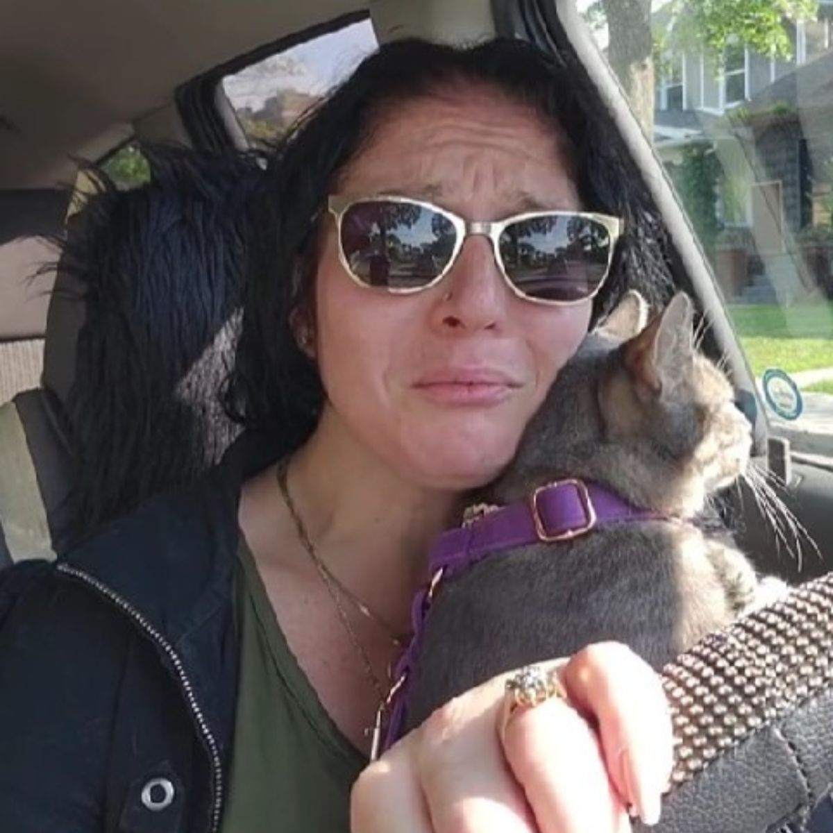 woman hugging a cat while driving