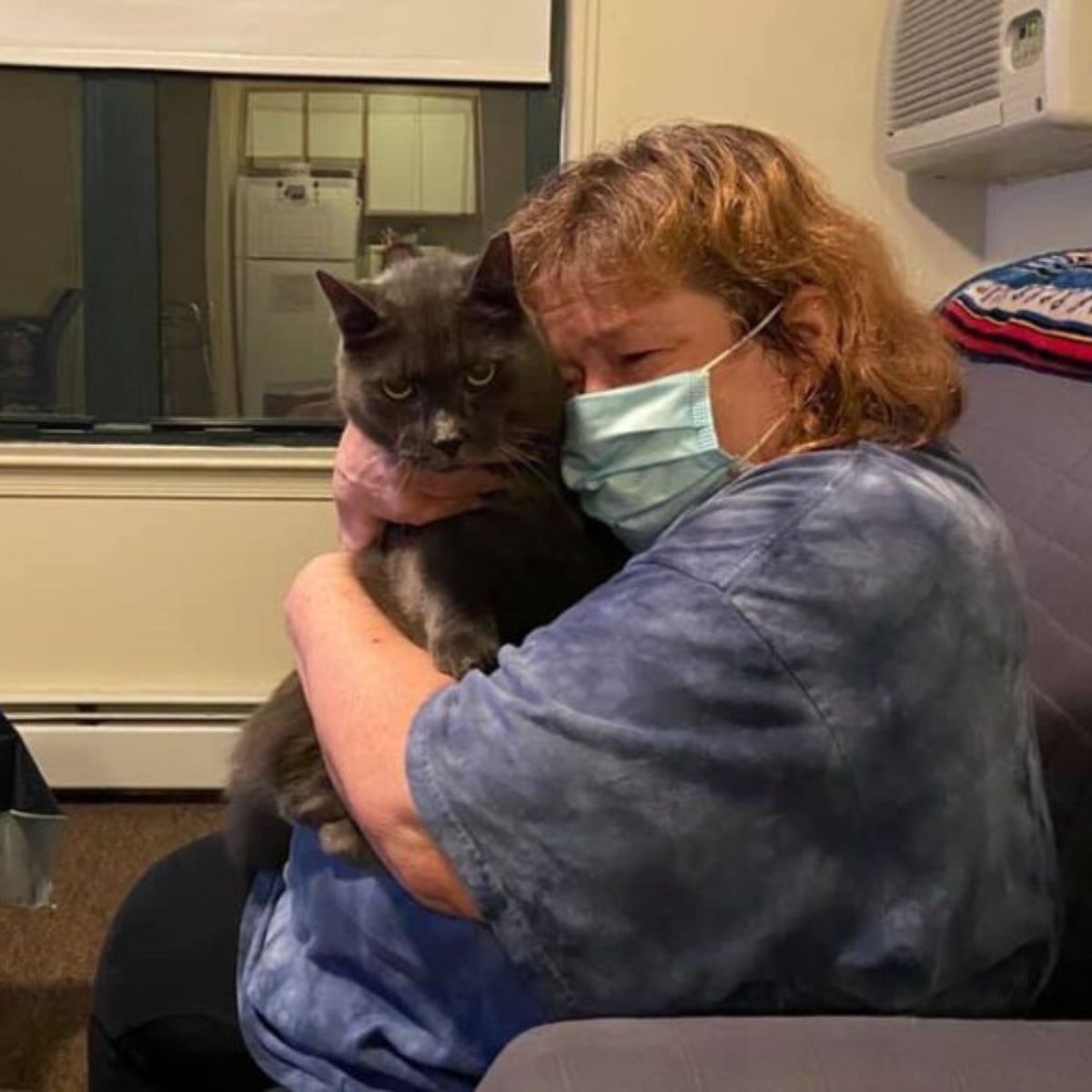 sad woman hugging senior cat