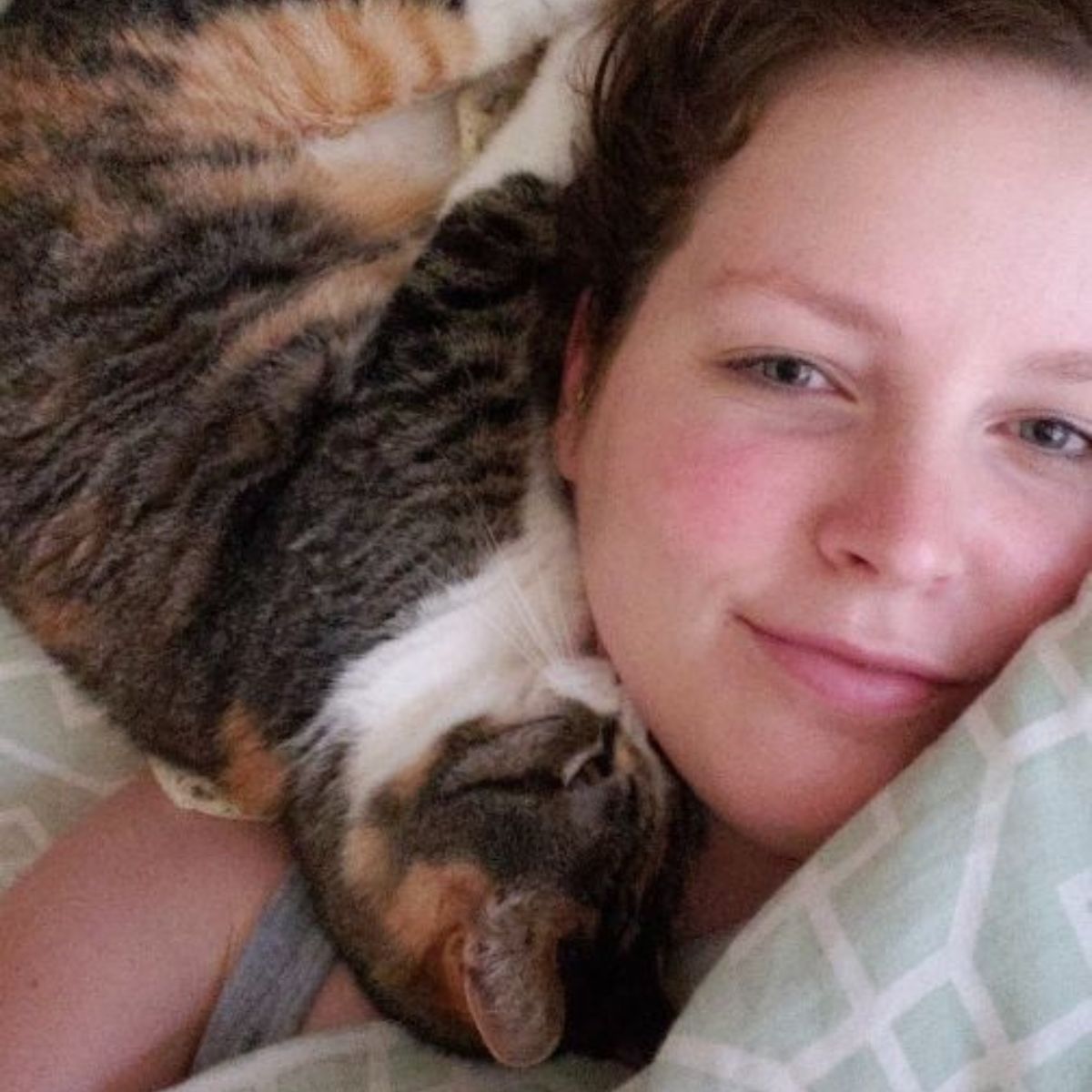 senior cat sleeping next to woman's head