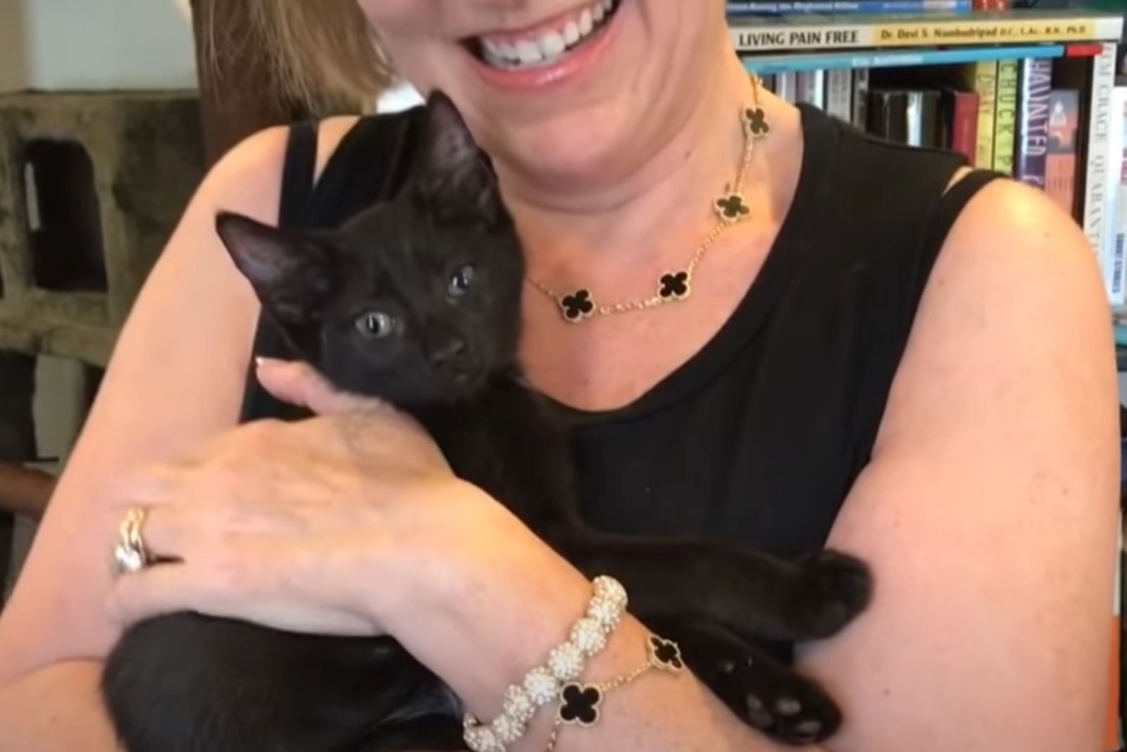 smiling woman and little black kitten