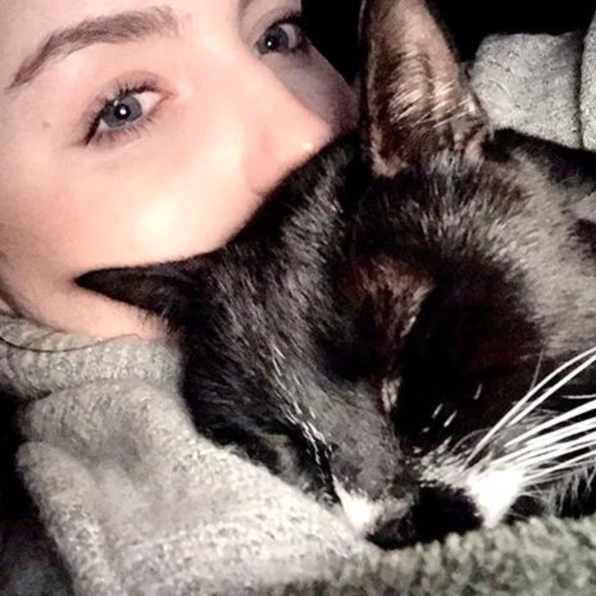 woman cuddles with a dark cat