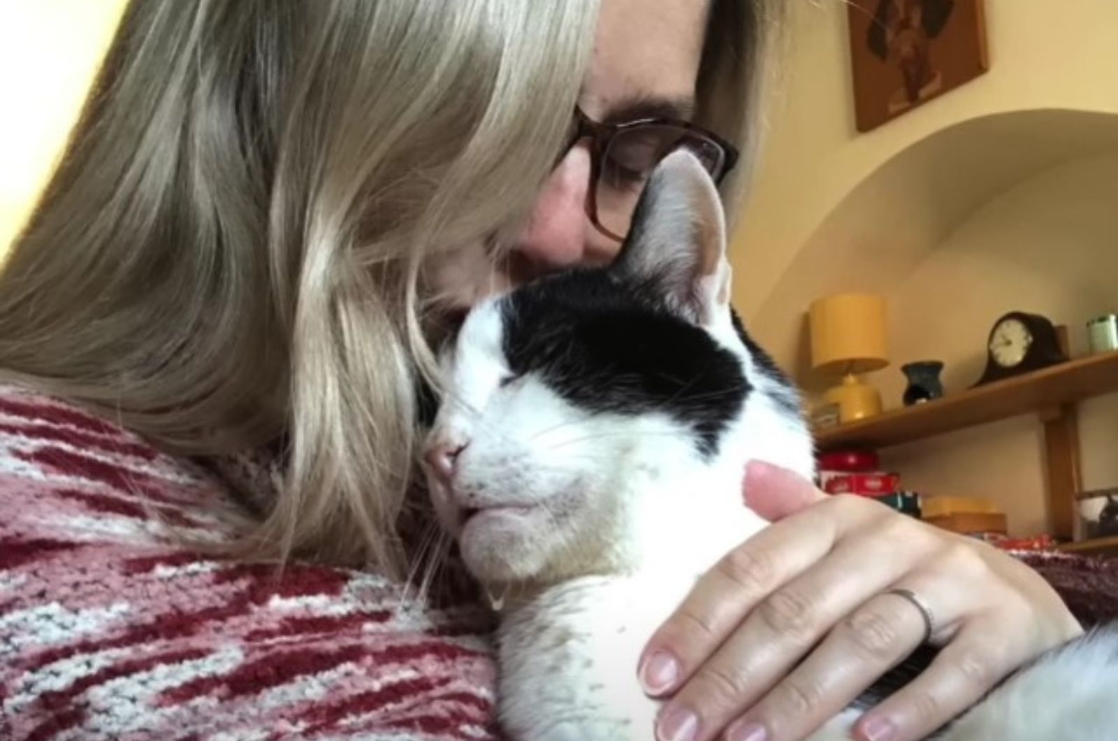 woman cuddling lovingly with cat