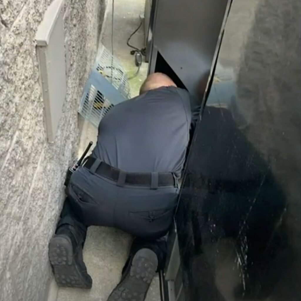 A man looks under a vending machine
