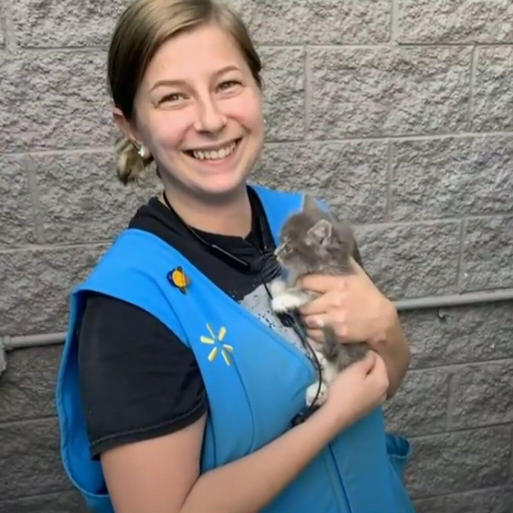 The girl is holding a kitten in her hands