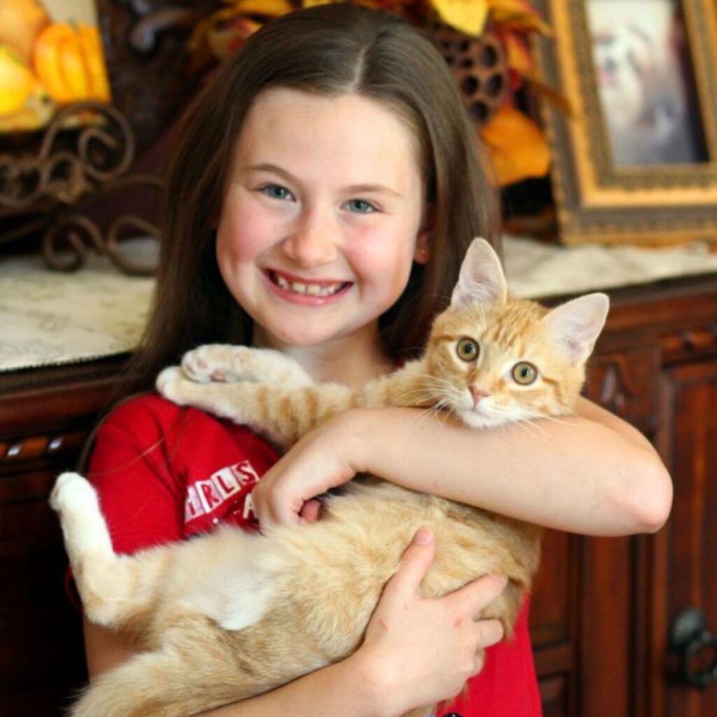 a girl holding a cat in her hands