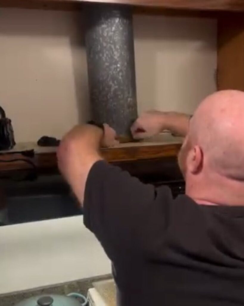 a man touches a stove pipe