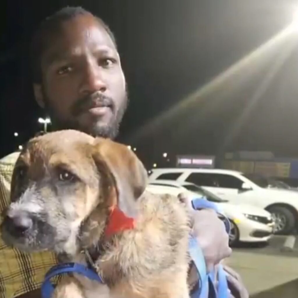 black man holding a dog in his arms