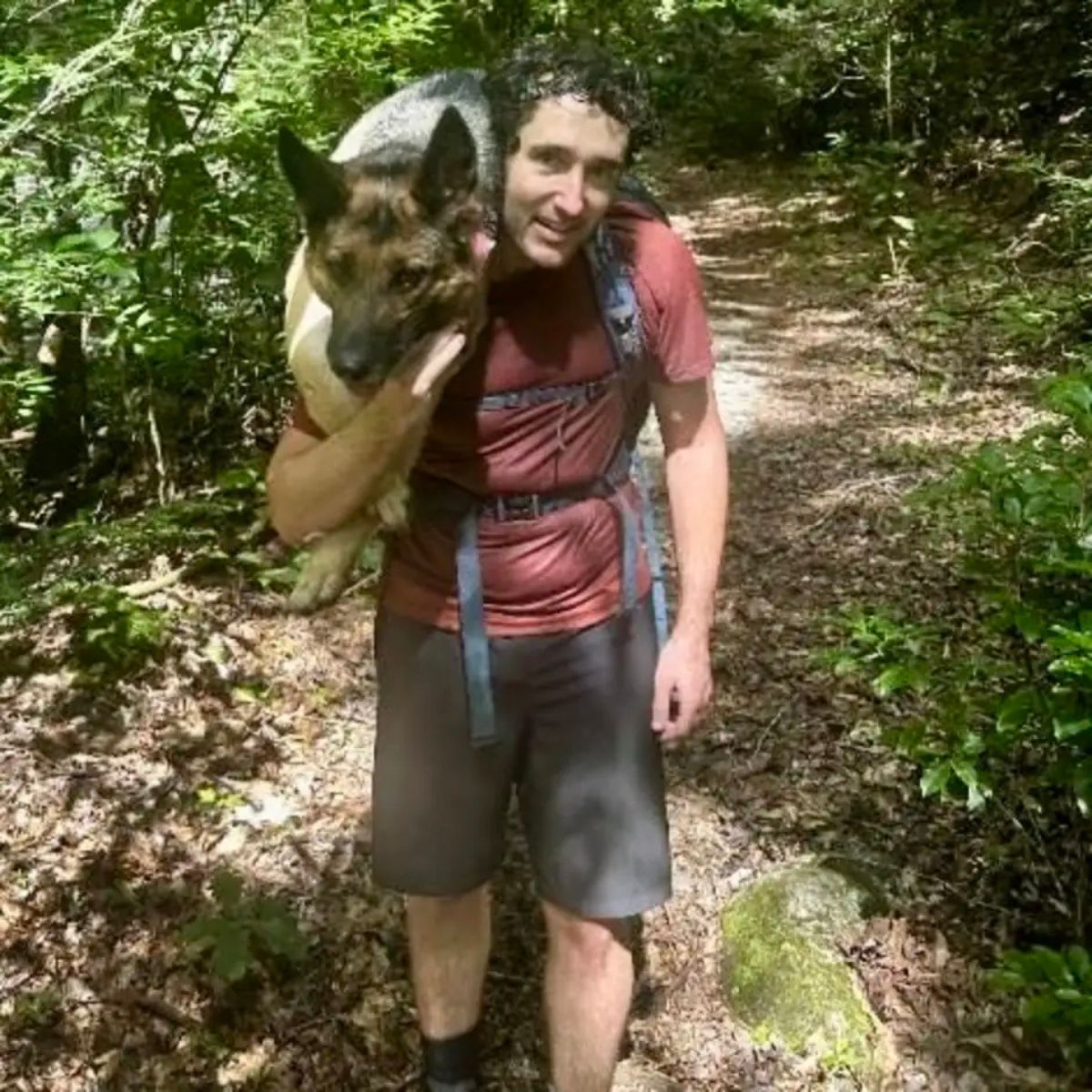 hiker carries dog on back