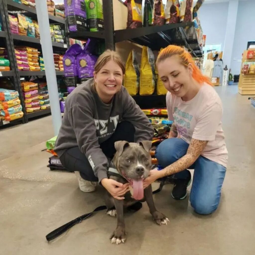 two girls in the market with a dog