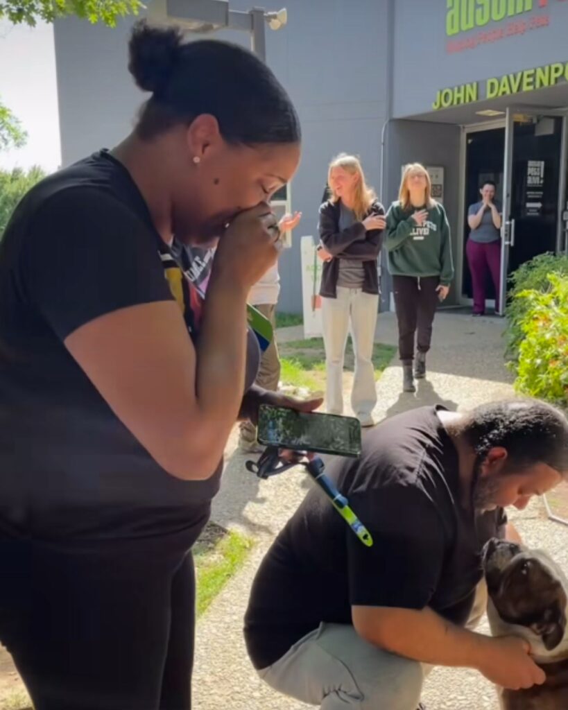 A crying woman looks at a dog