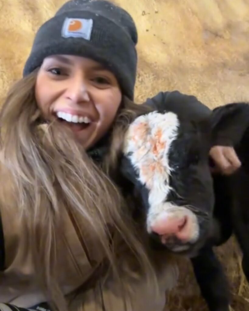 The girl is hugging the calf