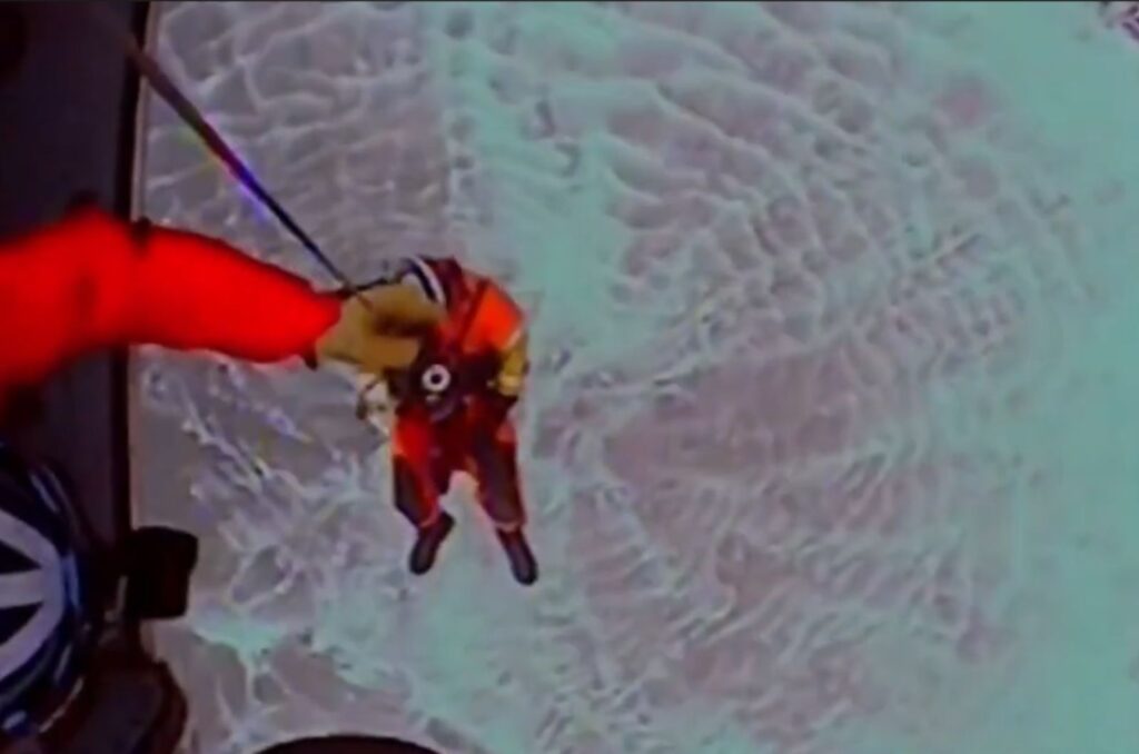 a man descends from a helicopter