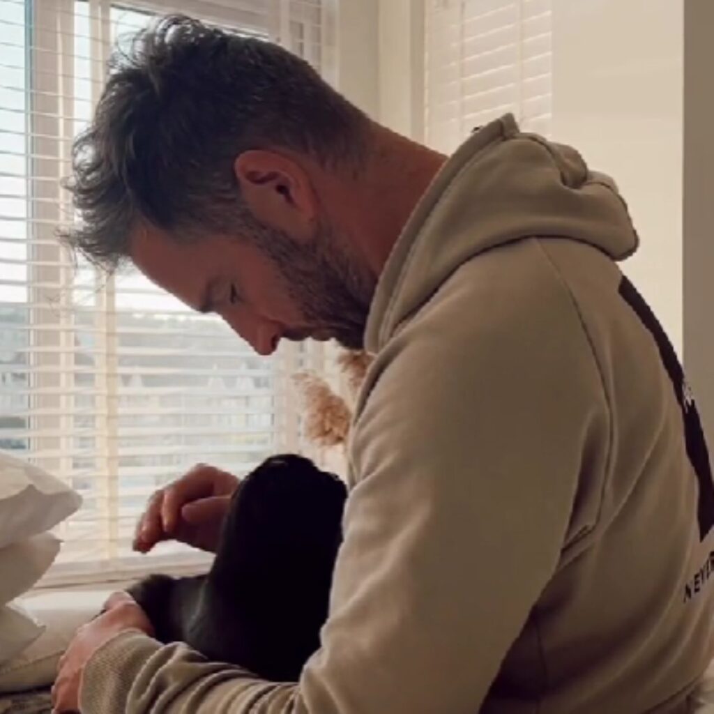 a man holds a dog in his arms