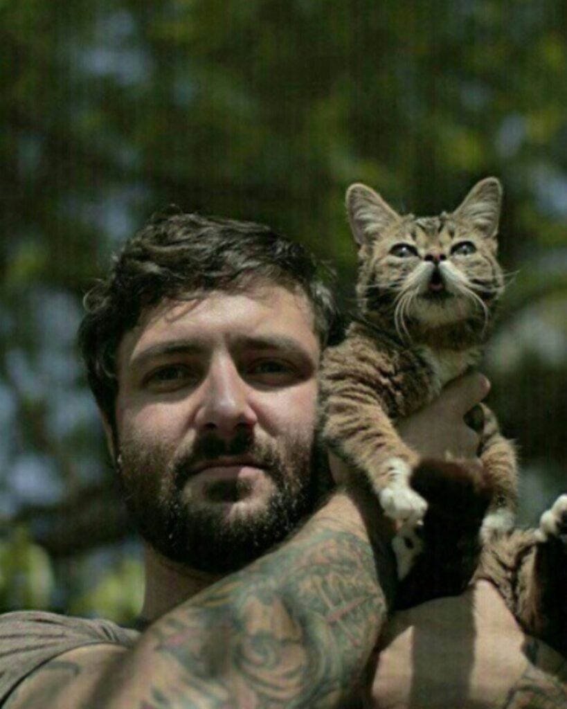 a man put a cat on his shoulder