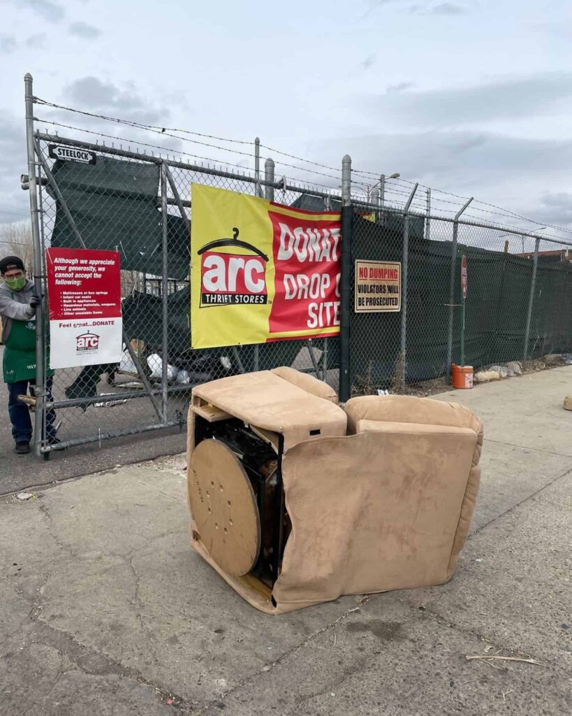 brown armchair thrown onto the sidewalk