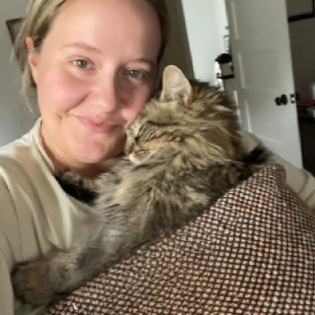 cat sleeping in woman's arms