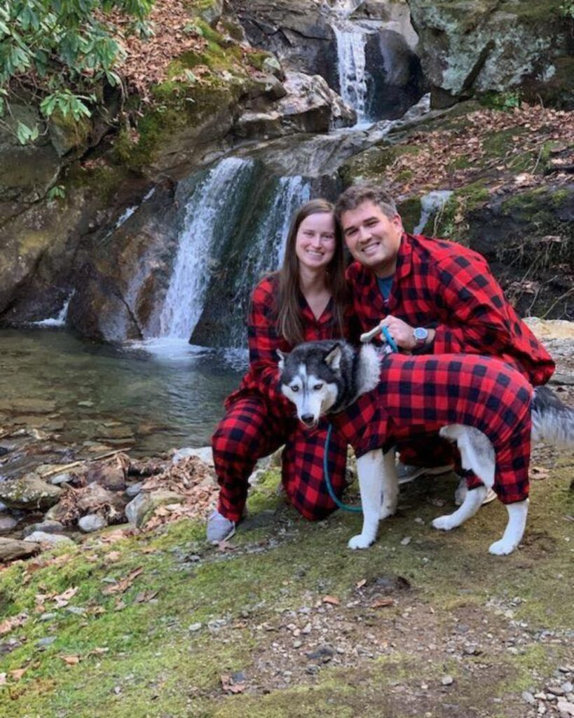 man and woman by a waterfall with a dog