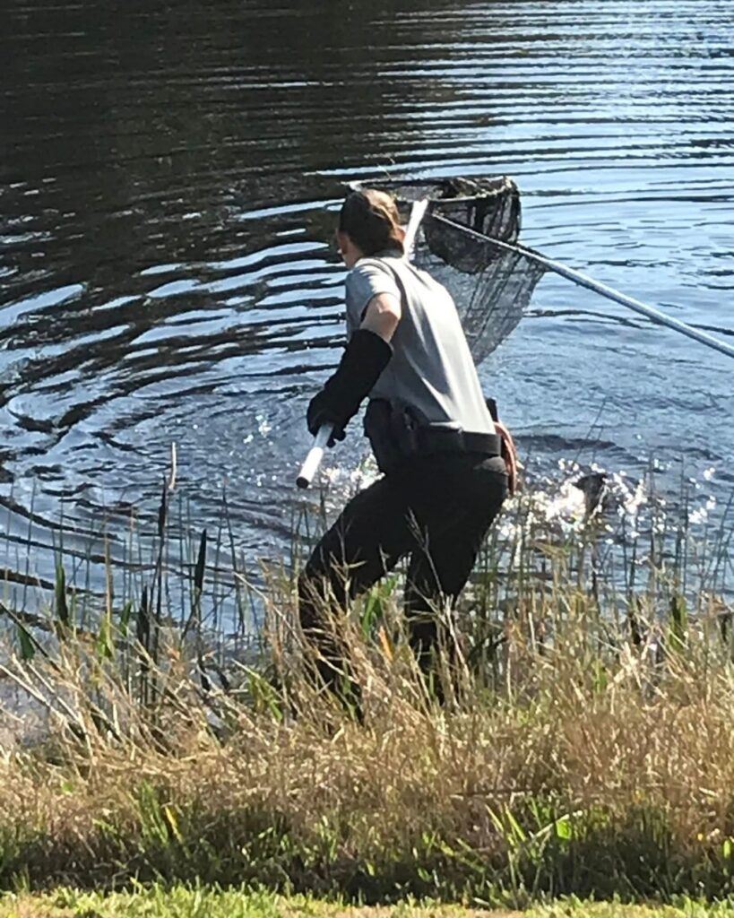 officer carrying a net above water