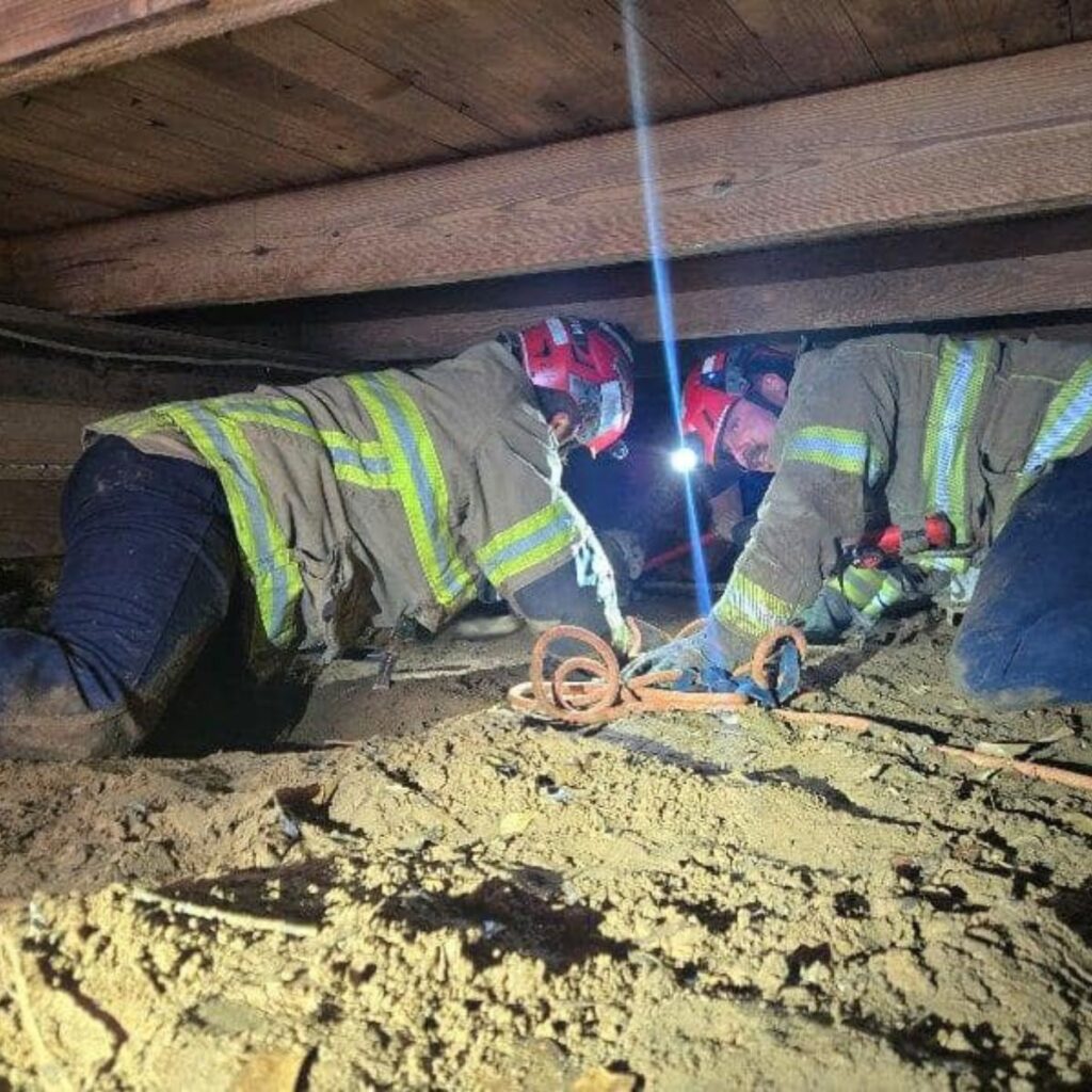 firefighters under a house