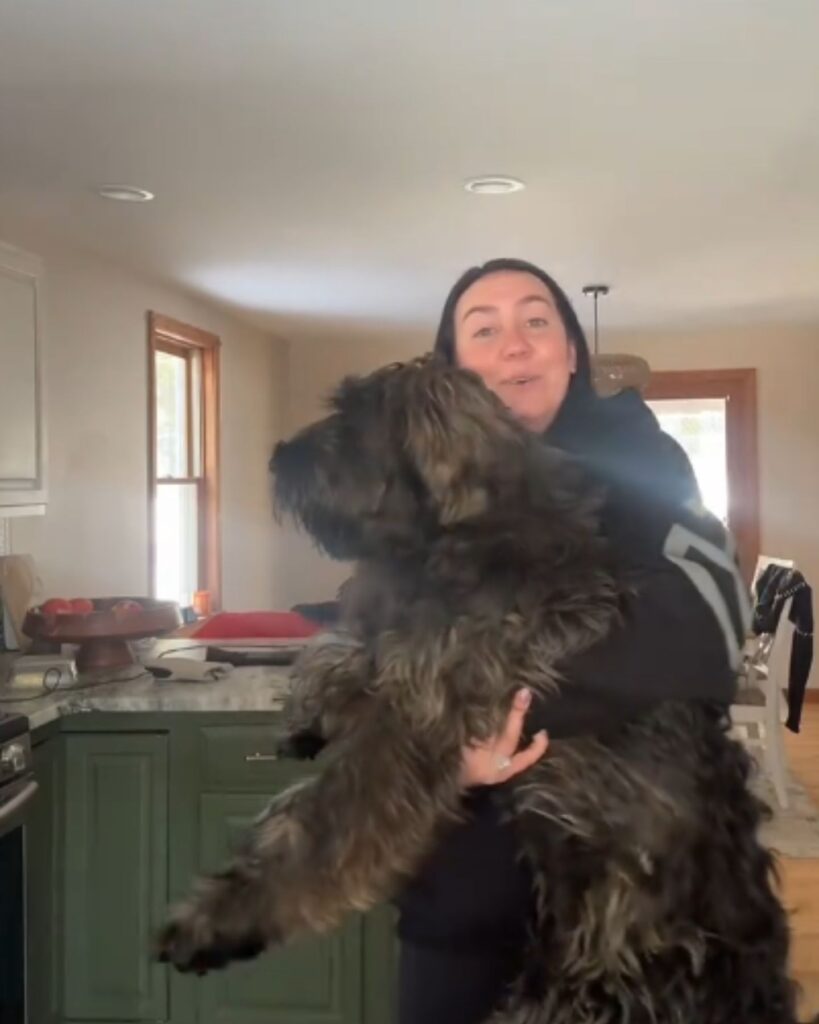 woman holding a big dog